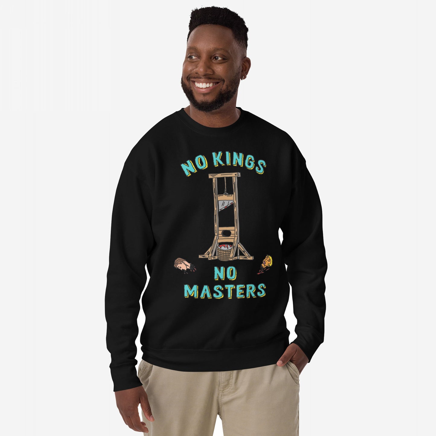 Man in a black No Kings No Masters Sweatshirt, featuring a bold guillotine graphic with severed heads and the slogans “NO KINGS” and “NO MASTERS”, embodying rebellion and rejection of authoritarianism.