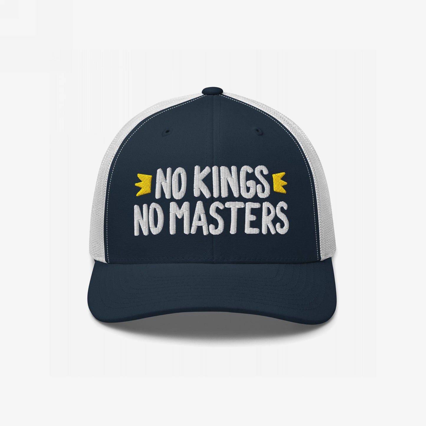 Trucker-style No Kings No Masters hat featuring navy front, white mesh back, and bold white embroidery. The cap embodies rebellion with hand-drawn accents, representing anti-authoritarian style and ethos.