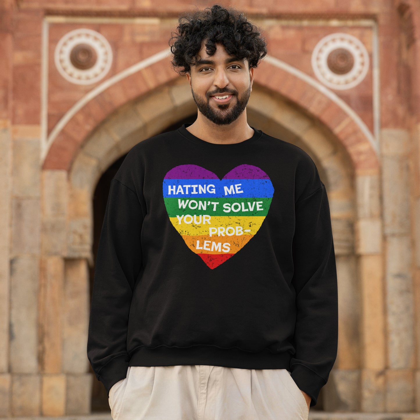 Man wearing the No LGBTQ Hate Hoodie & Sweatshirt with a rainbow-striped heart and bold text, HATING ME WON'T SOLVE YOUR PROBLEMS, embodying pride and resistance.