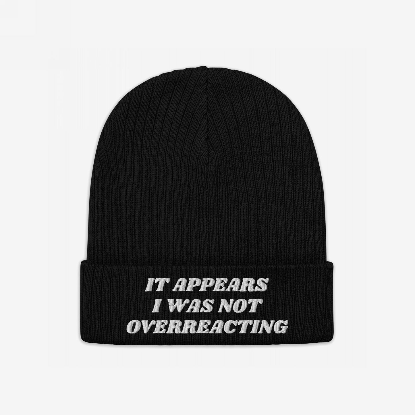 Black knit beanie with “IT APPEARS I WAS NOT OVERREACTING.” embroidered in white on the cuff, embodying the Overreacting Hat's bold statement for progressive activism and resistance.