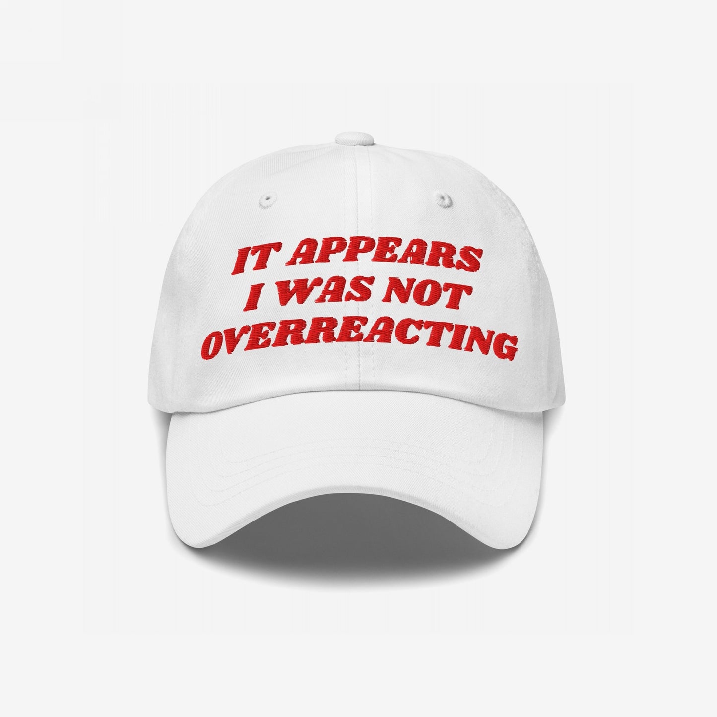 The Overreacting Hat features red embroidered text IT APPEARS I WAS NOT OVERREACTING on a white cap, symbolizing resilience against political gaslighting, perfect for activists and truth-tellers.