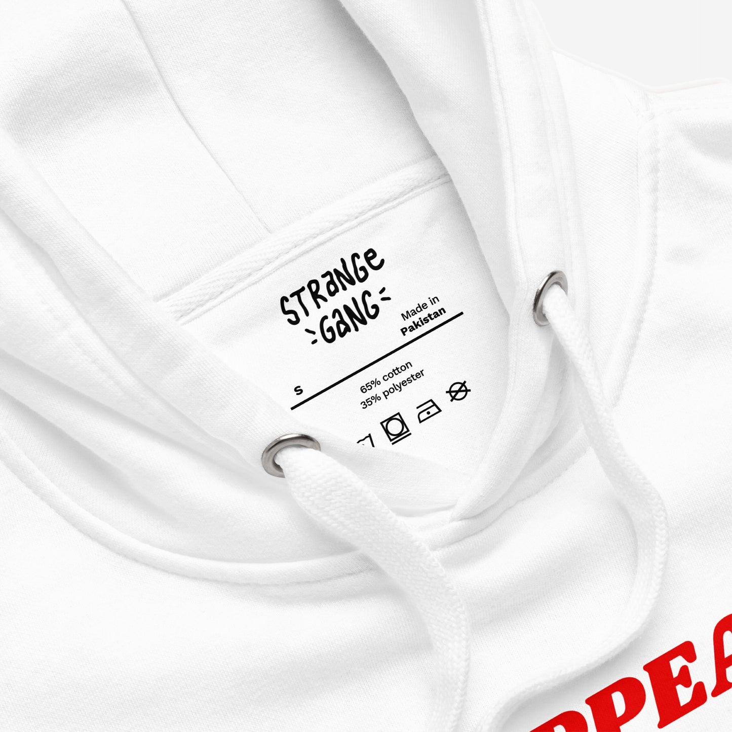 Overreacting Hoodie & Sweatshirt close-up: Inside neck shows branding tag Made in Pakistan, size S, cotton-polyester blend, laundry symbols, with white drawcords and part of bold red graphic confronting fascism.