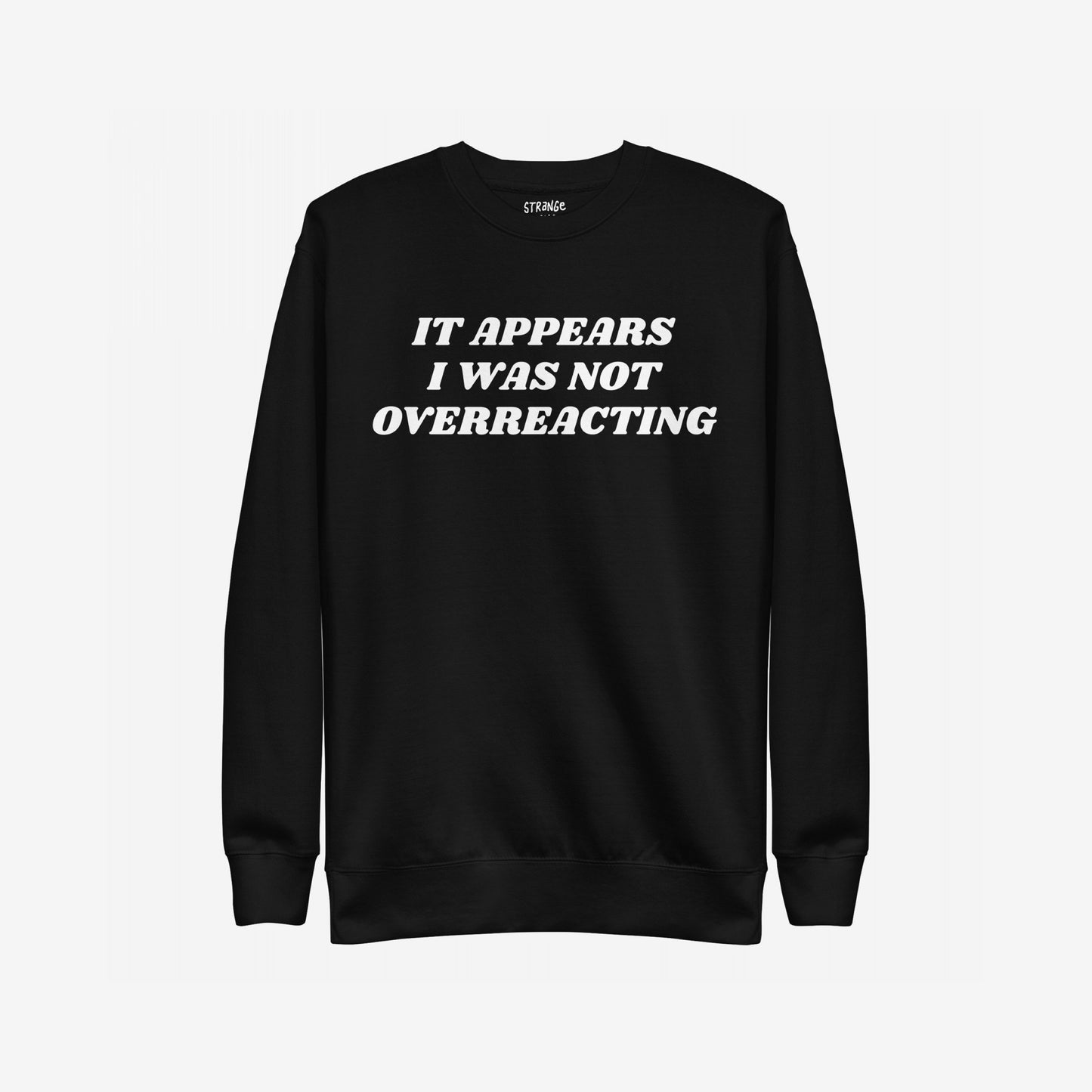 Black crewneck sweatshirt titled Overreacting Hoodie & Sweatshirt features bold white text: IT APPEARS I WAS NOT OVERREACTING, symbolizing resistance and defiance against oppressive systems. Brand label visible inside collar.