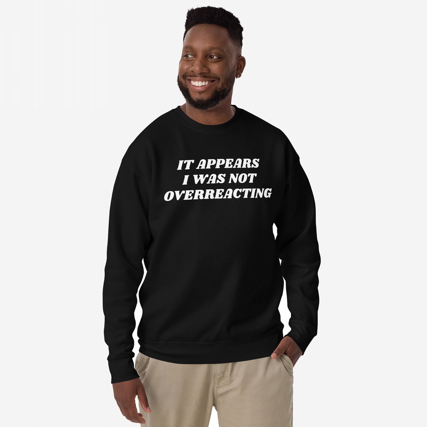 Man wearing Overreacting Hoodie & Sweatshirt, featuring bold white text, “IT APPEARS I WAS NOT OVERREACTING,” standing confidently with one hand in his pocket against a plain background.