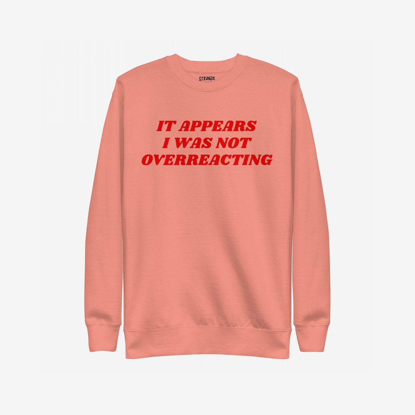 Overreacting Hoodie & Sweatshirt features bold red lettering stating, “IT APPEARS I WAS NOT OVERREACTING,” on a muted coral crewneck, embodying resistance against oppression and supporting equality.