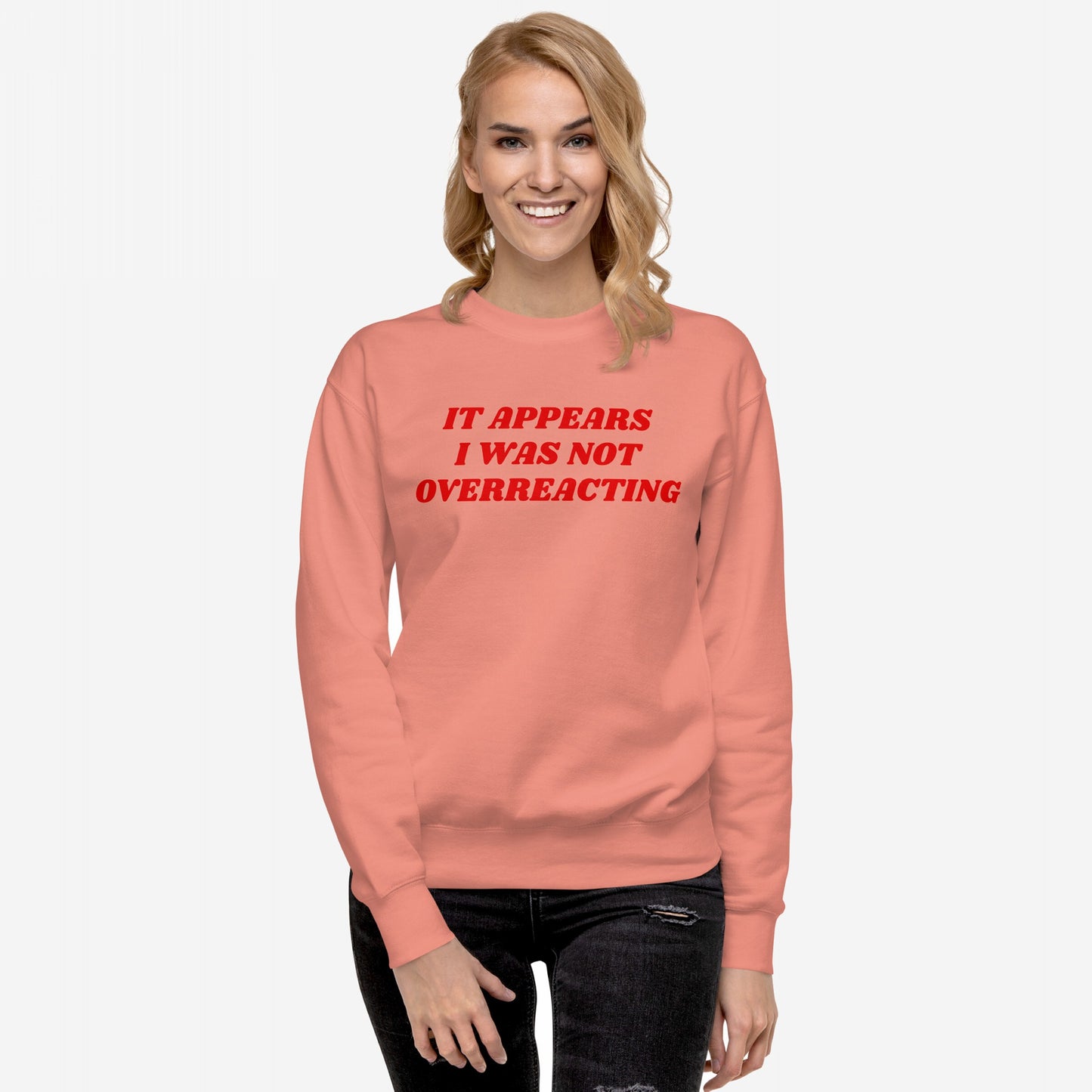 Overreacting Hoodie & Sweatshirt features a woman in a coral crewneck with bold text, embodying resistance and advocacy against oppressive systems, reflecting a strong, unapologetic stance against fascism.