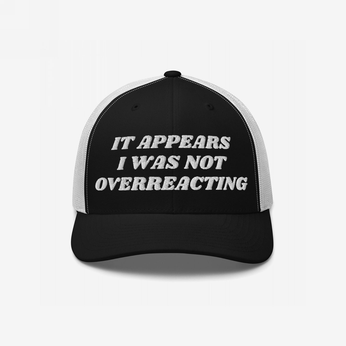 The Overreacting Hat features bold white embroidery of the phrase It appears I was not overreacting on a black-and-white mesh-back trucker cap, symbolizing resistance against political gaslighting.