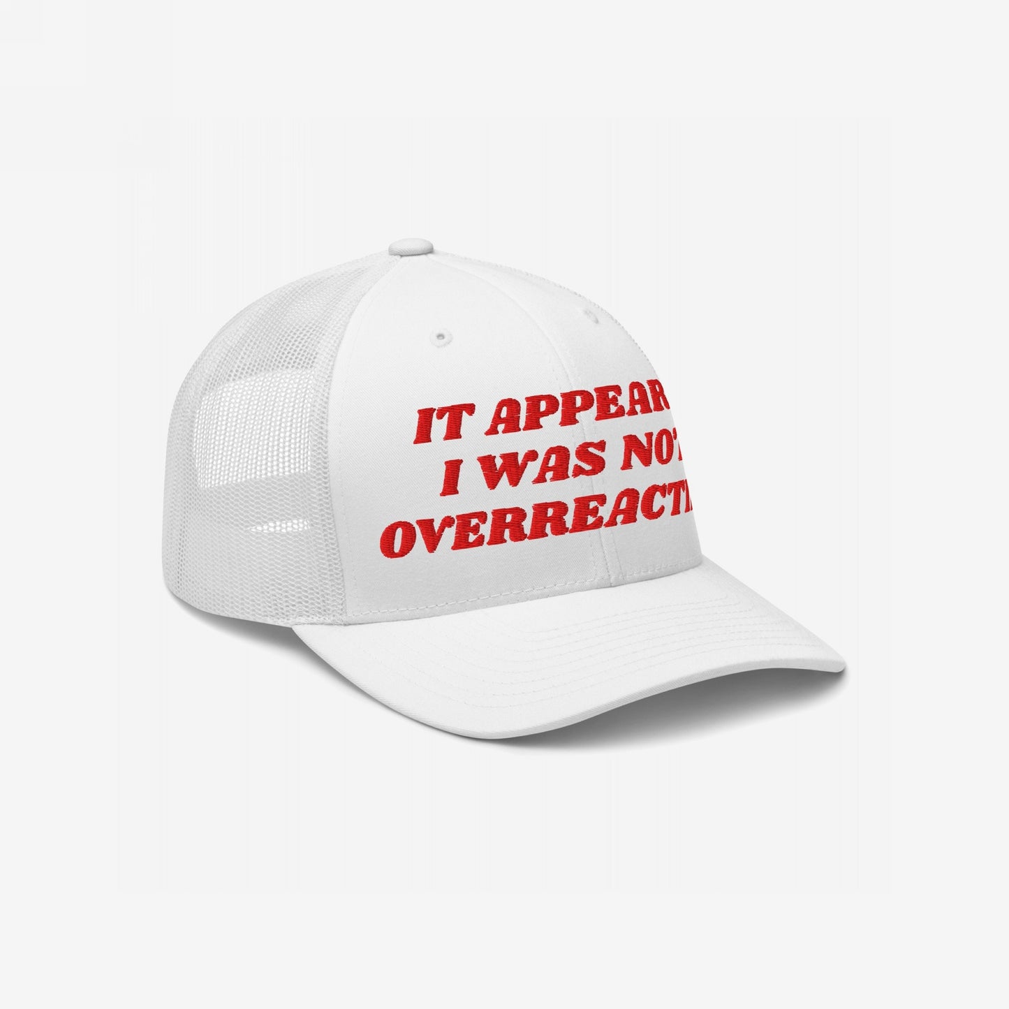 White mesh-back trucker hat with red embroidered text: It Appears I Was Not Overreacting. The Overreacting Hat embodies progressive activism, perfect for those challenging injustices and supporting equality.