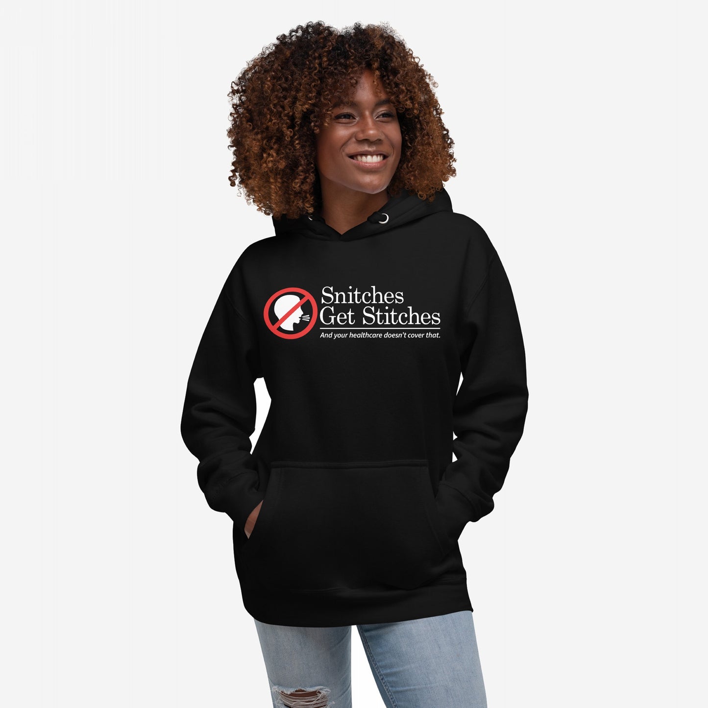 Snitches Get Stitches Hoodie features a bold graphic of a no symbol over a whispering profile, with text mocking snitches and healthcare, worn by a smiling person with hands in the front pocket.