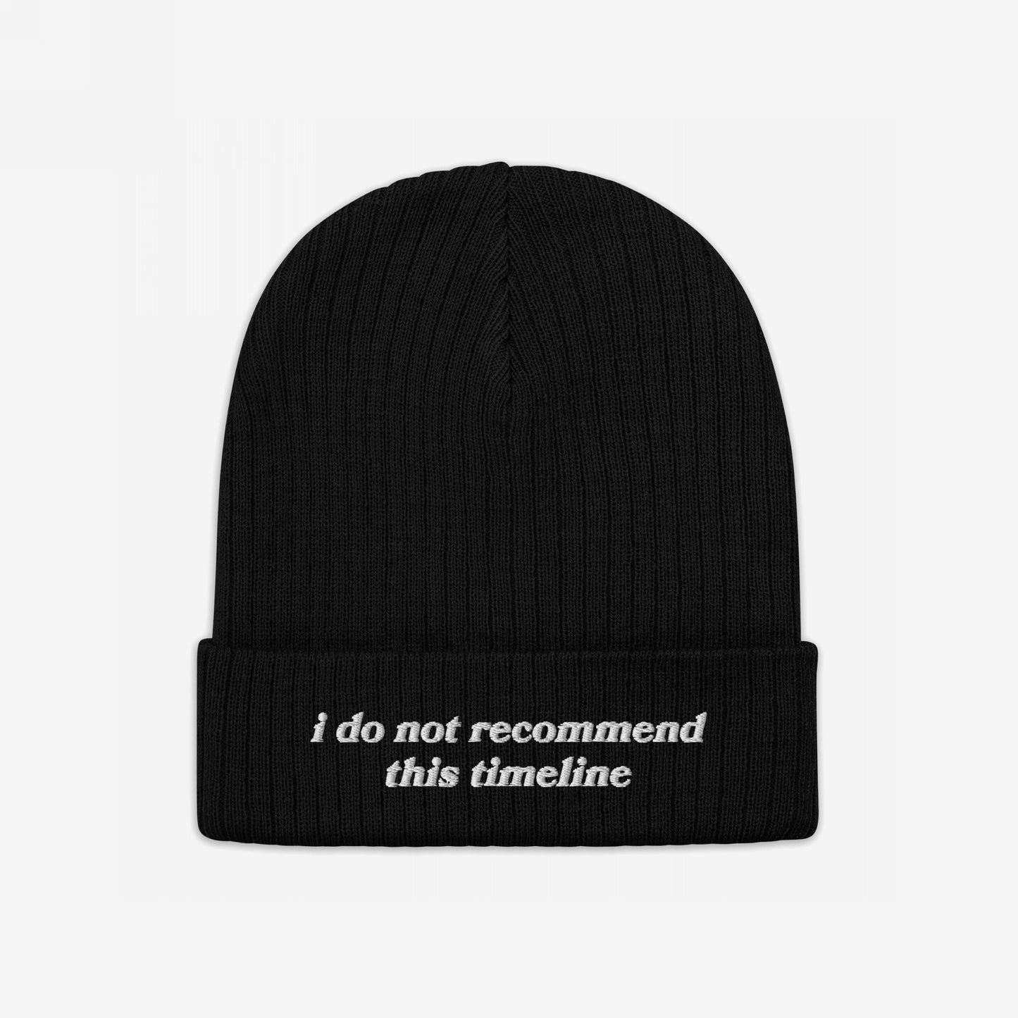 A black rib-knit beanie, the Timeline Hat, features i do not recommend this timeline embroidered on its cuff, embodying a sarcastic stance against current events.