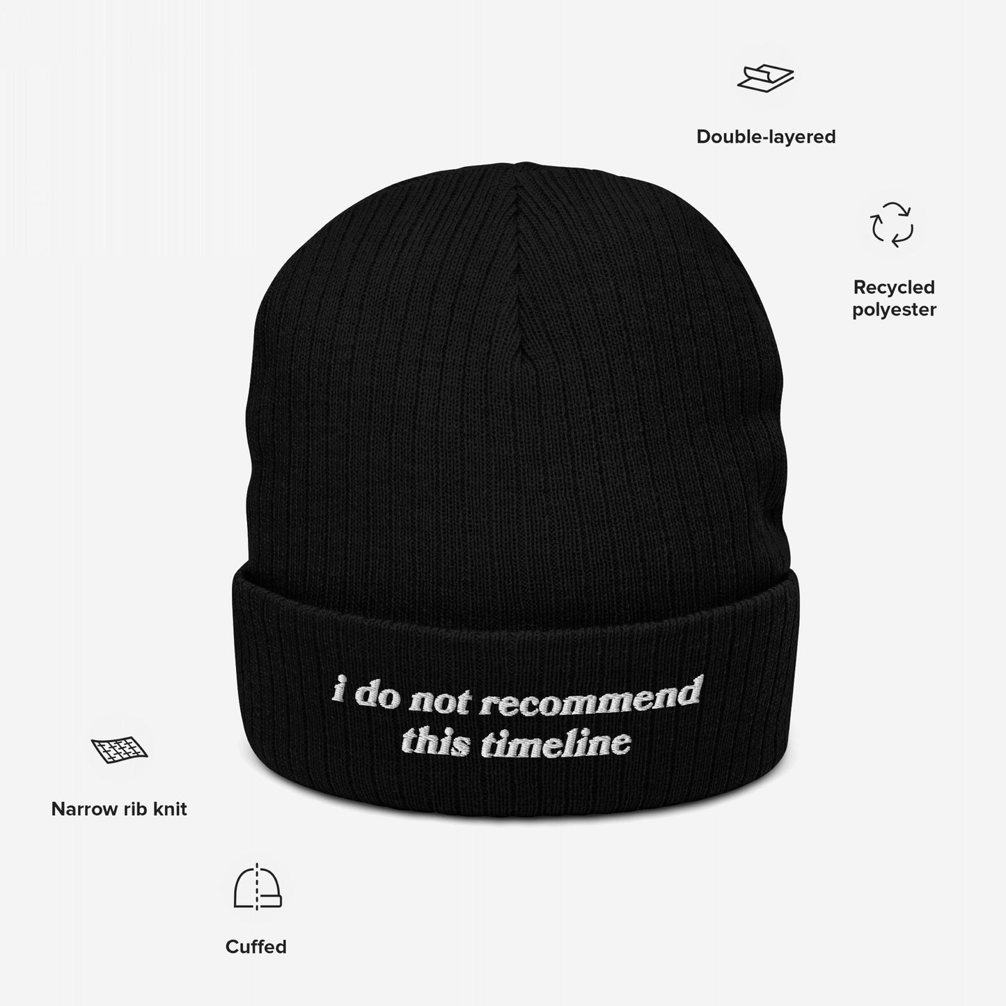 The Timeline Hat, a black cuffed knit beanie made from recycled polyester, features white embroidered text stating “i do not recommend this timeline,” perfect for expressing discontent with current events.