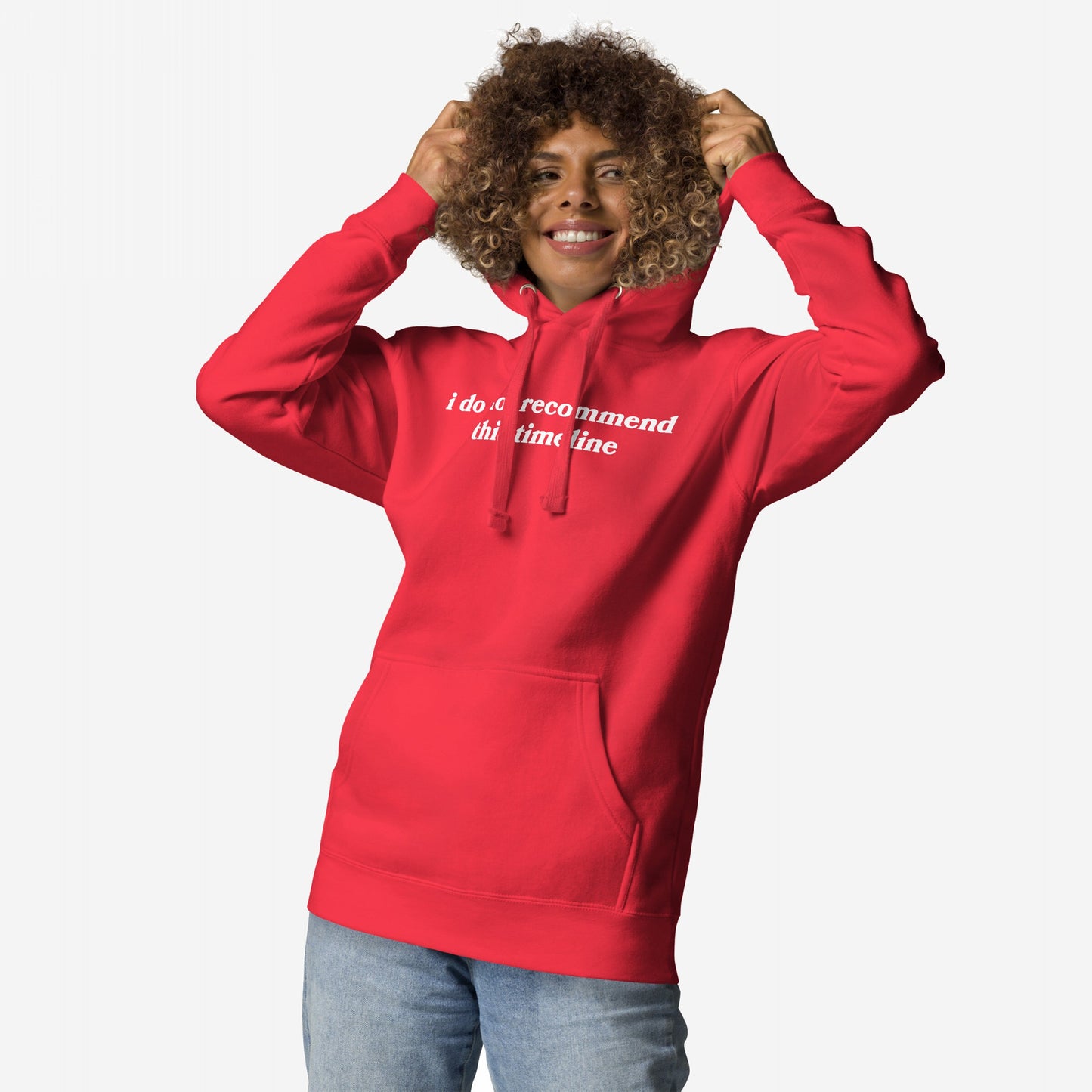 Timeline Hoodie & Sweatshirt: A person in a red hoodie with I do not recommend this timeline text, embodying dry wit and dystopian fashion, smiling while adjusting the hood.