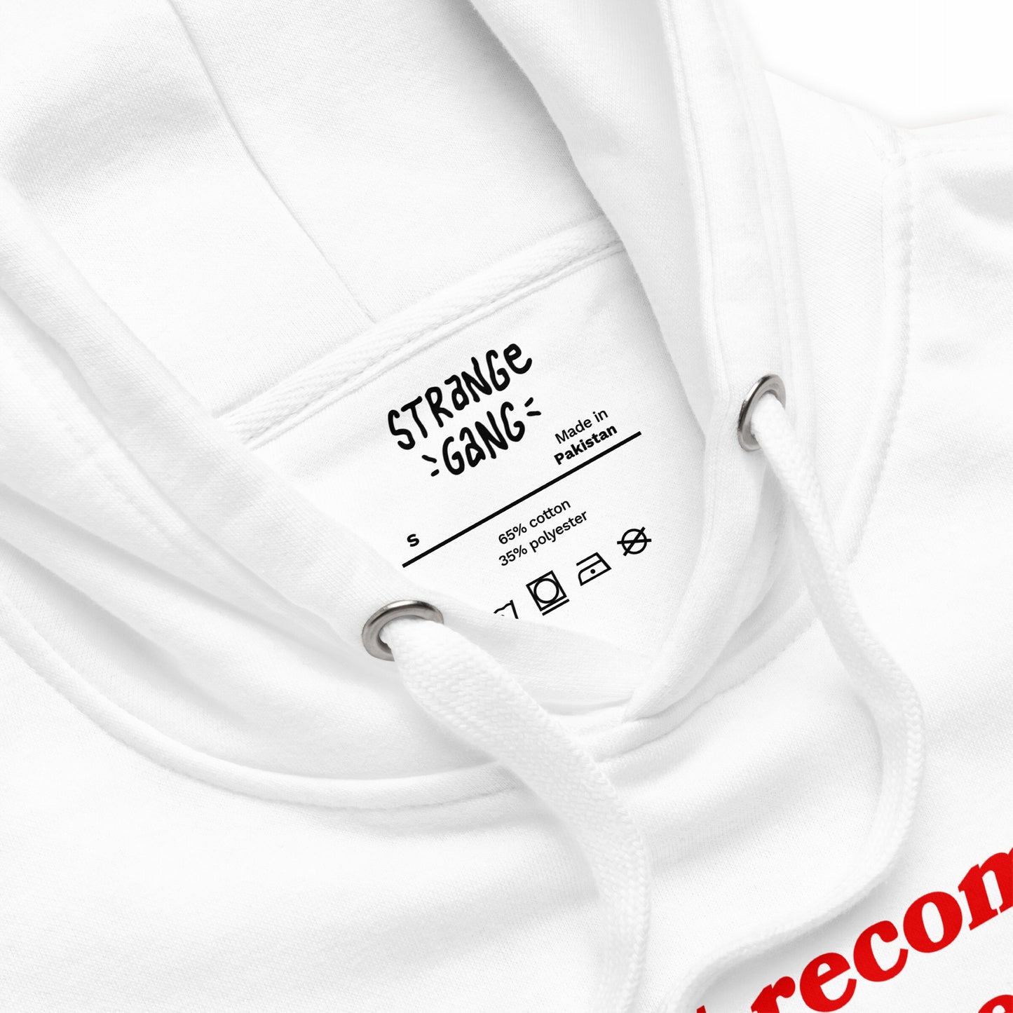 Close-up of the Timeline Hoodie, featuring a printed care label inside the neck with brand details. Visible are white drawcords with metal eyelets and a hint of red print below.