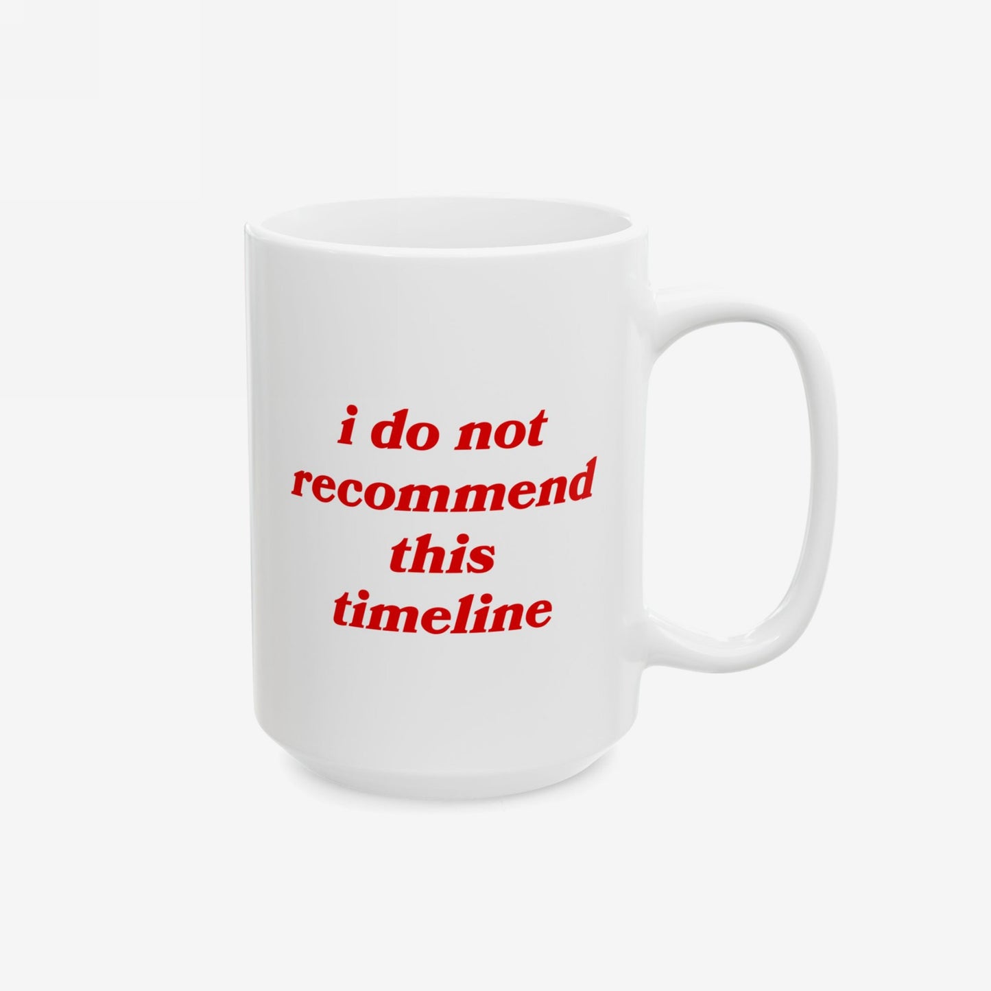 White ceramic Timeline Mug with red italic text: i do not recommend this timeline. Perfect for those facing societal collapse with sarcasm. Dishwasher-safe, emotional unavailable, available in 11 oz. and 15 oz.