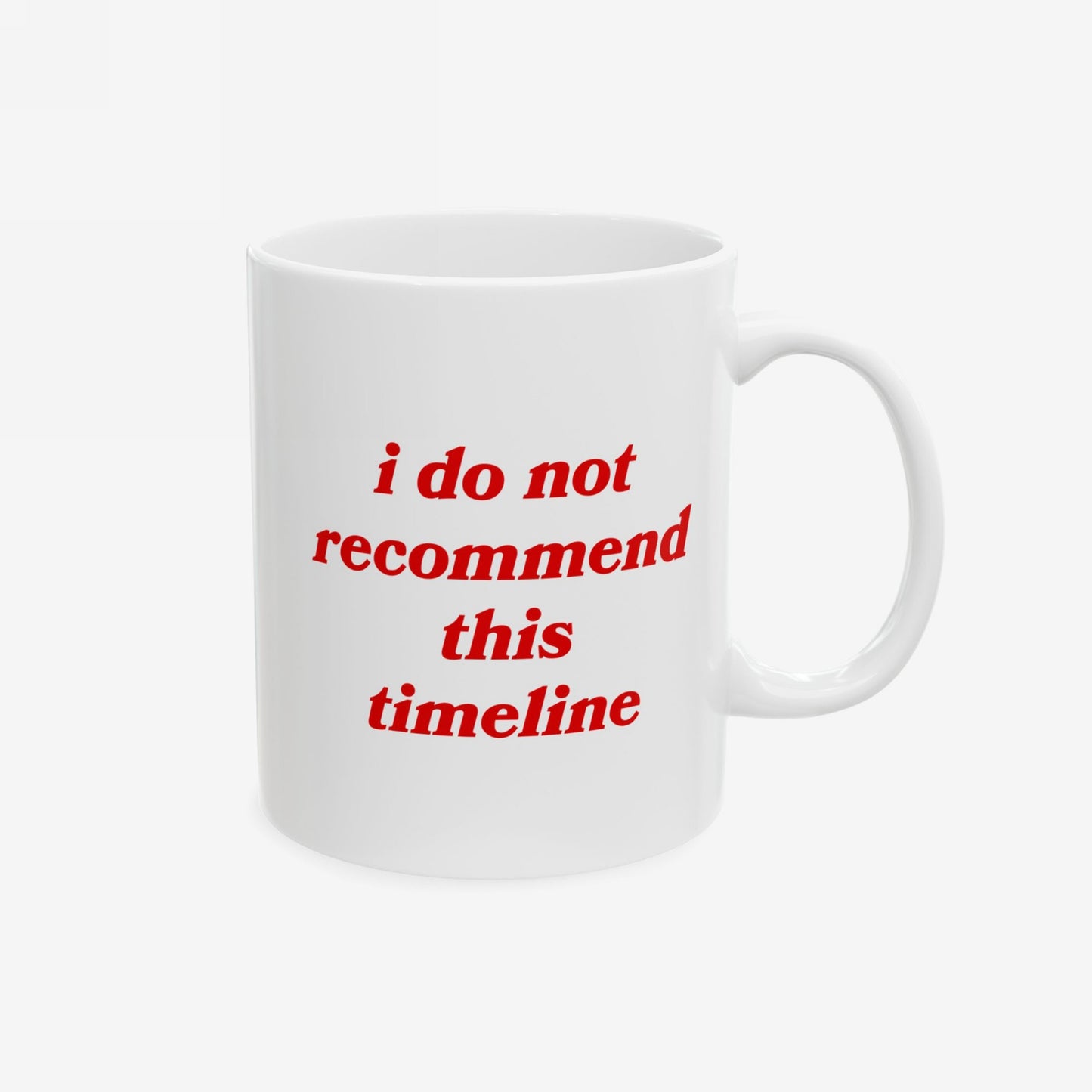 The Timeline Mug displays red italic text, i do not recommend this timeline, on a plain white ceramic surface, embodying sarcasm for those navigating societal collapse.