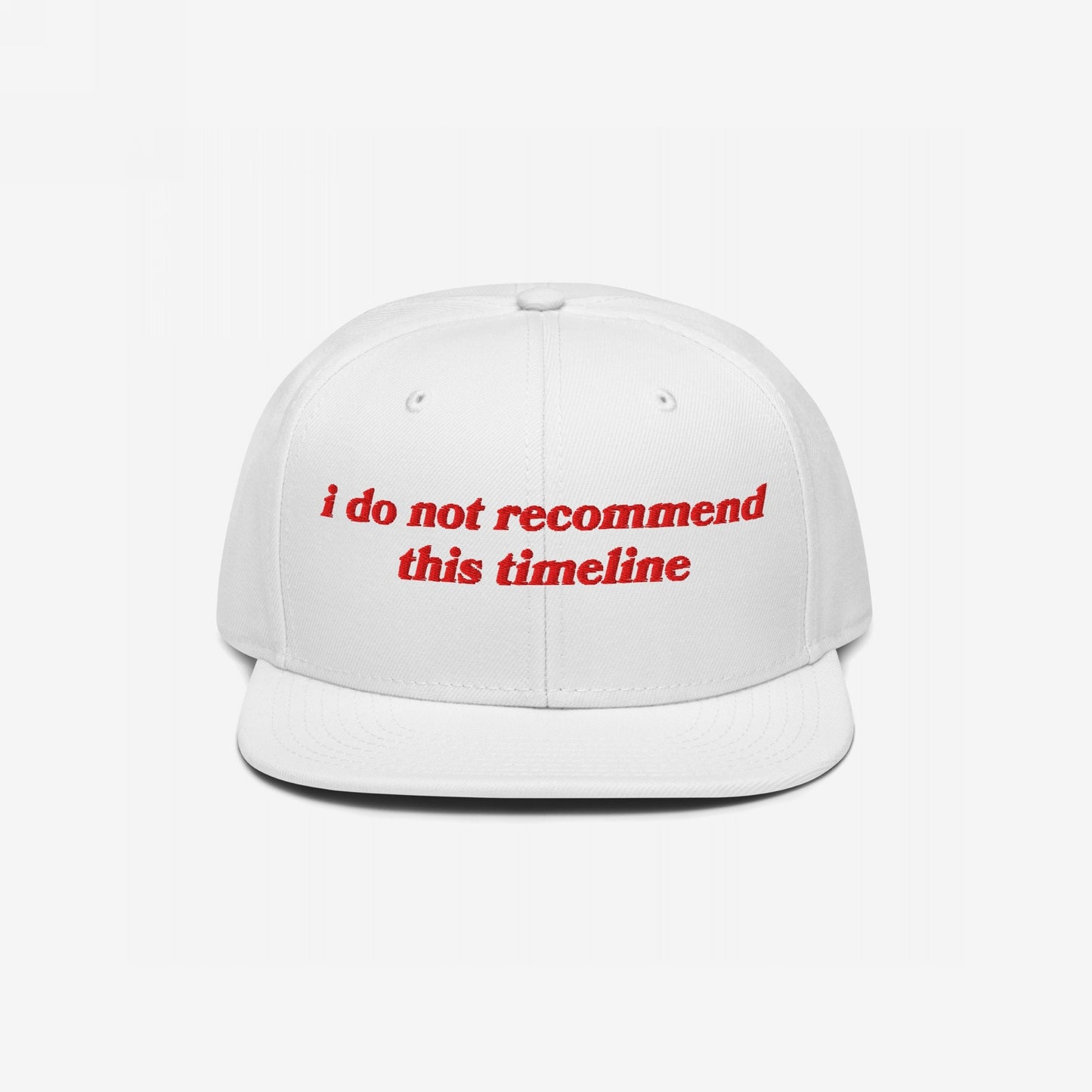 White Timeline Hat with red vintage-inspired embroidery stating “i do not recommend this timeline.” Perfect for expressing political discontent with style, available in various styles like snapback and beanie.