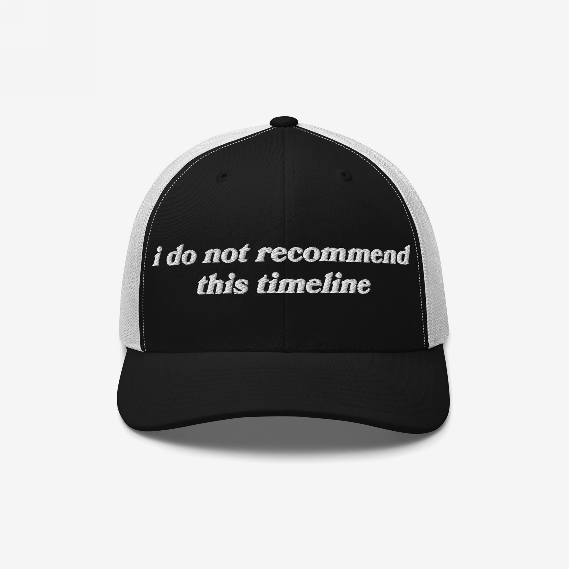 Timeline Hat: A black-and-white trucker cap with a black front panel featuring white embroidered text, i do not recommend this timeline, and a white mesh back, embodying ironic political humor.