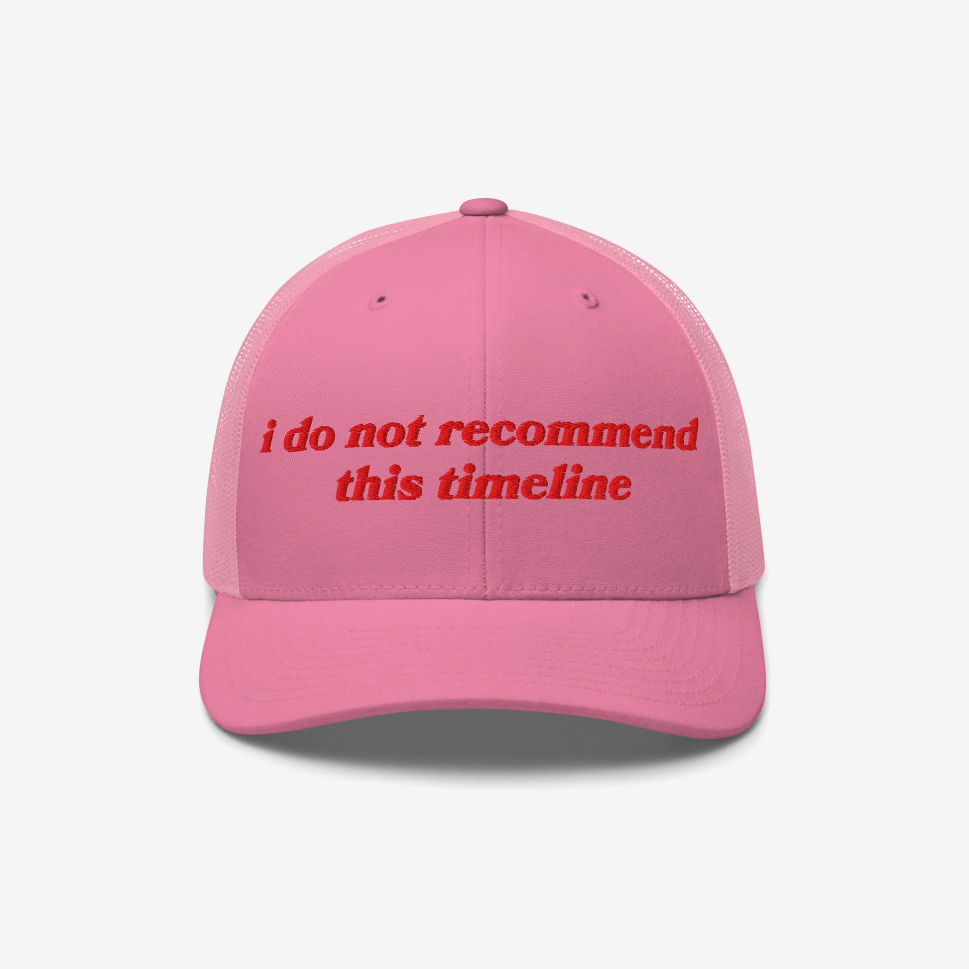 Pink mesh-back trucker hat with red embroidered text i do not recommend this timeline, humorously reflecting political irony. Ideal for those embracing sarcasm and realism in chaotic times.