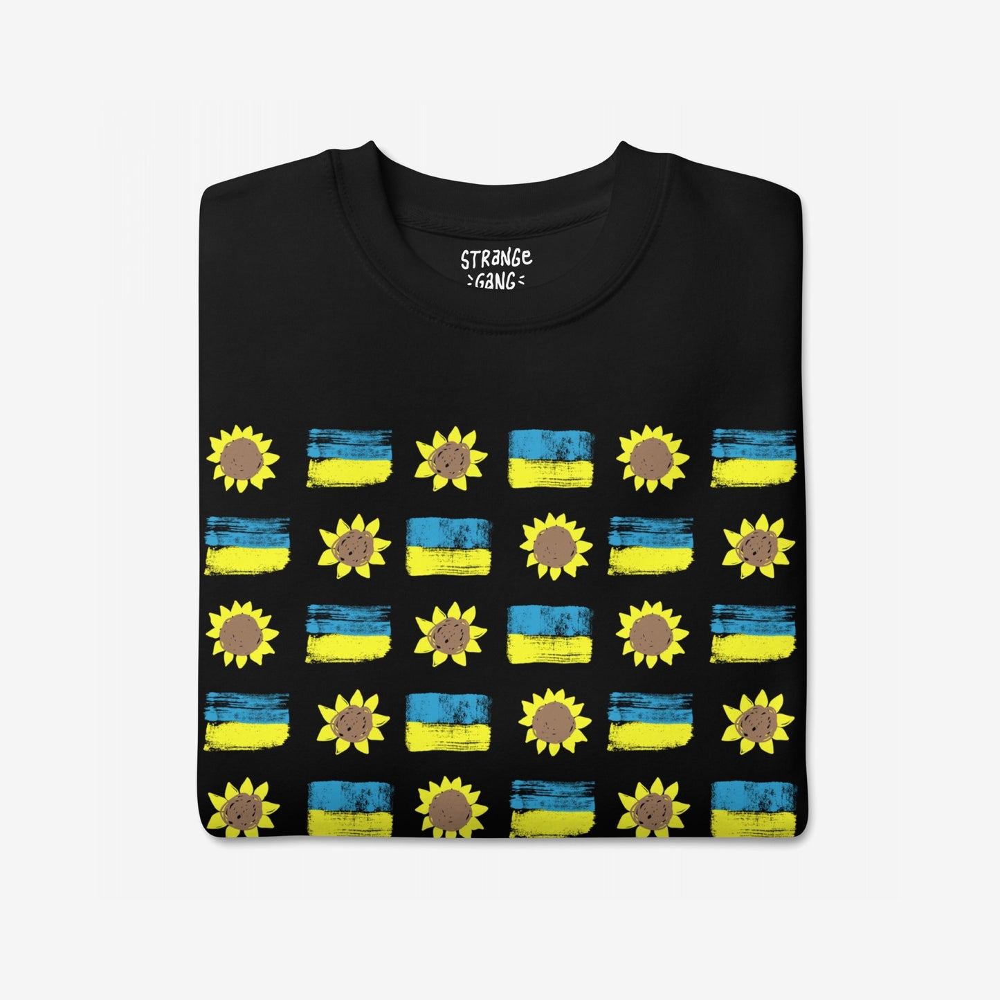 Ukraine Sunflowers Sweatshirt features a grid pattern of blue-yellow flags and sunflowers, symbolizing unity and courage. The folded black T-shirt highlights resilience and solidarity in support of Ukraine.