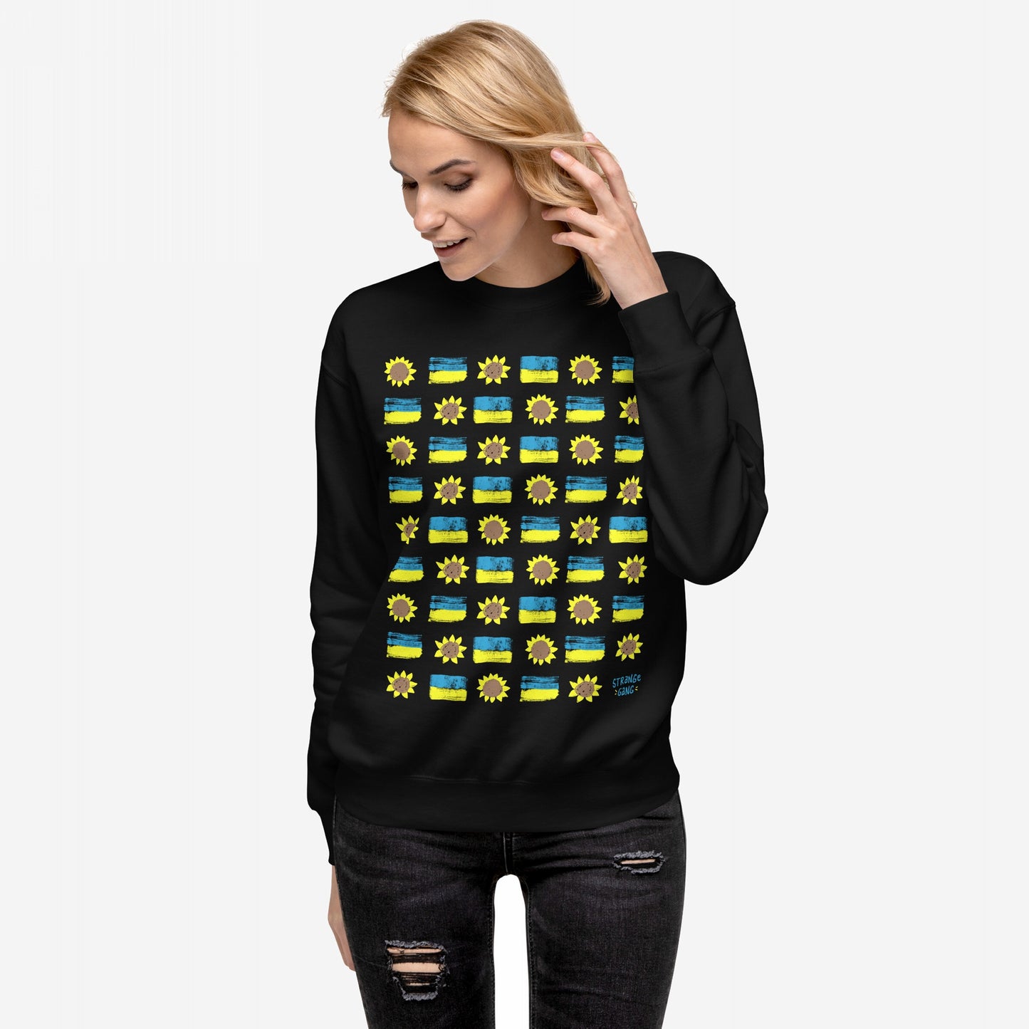 Ukraine Sunflowers Sweatshirt: A black crewneck featuring a grid of hand-drawn yellow sunflowers and bicolor stripes symbolizing the Ukrainian flag, representing unity and resilience. Model pairs it with distressed jeans.