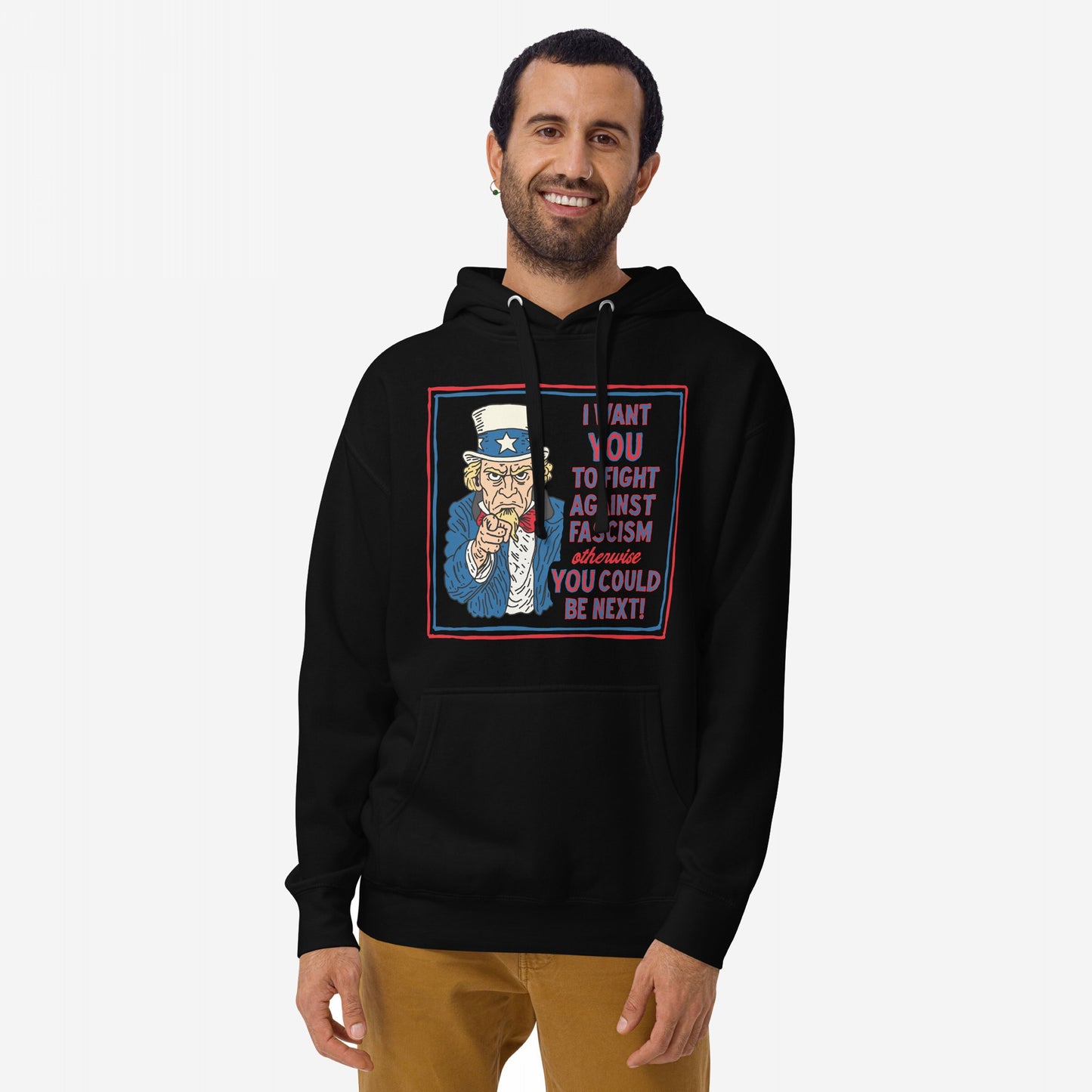 Man wearing black Anti-Fascist Uncle Sam Hoodie, featuring bold Uncle Sam artwork and text urging action against fascism. The design is part of a collection promoting equality and resistance.