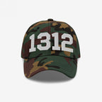 Camouflage-patterned baseball cap featuring 1312 in prominent white embroidery, symbolizing ACAB. The cap has a curved brim and six-panel design, embodying a message of police accountability and resistance.