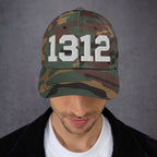 Person wearing a woodland-pattern camouflage baseball cap with bold white 1312 on the front, representing the protest code ACAB. Ideal for those advocating police accountability and standing against brutality.