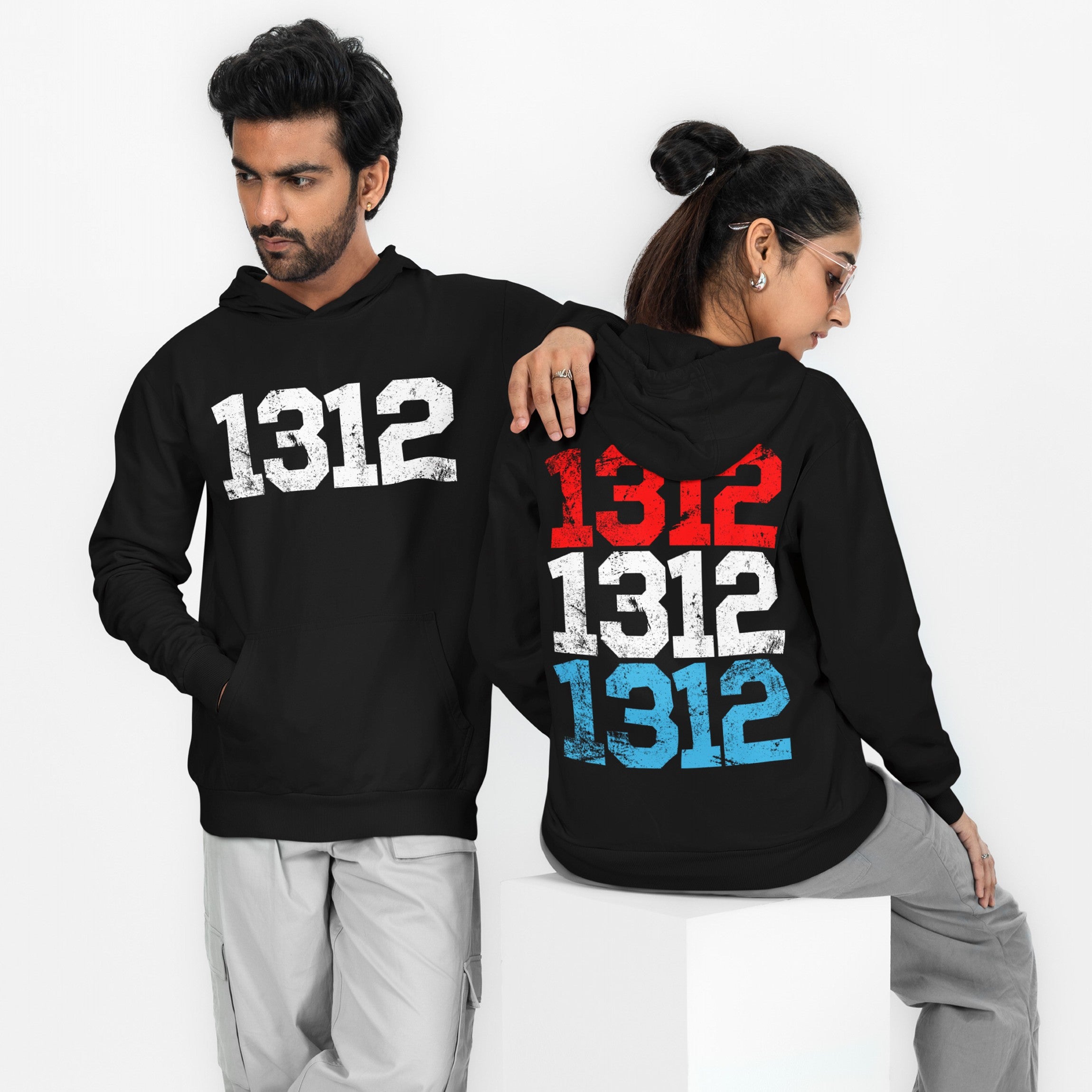 Two models showcase the 1312 ACAB Hoodie: left model displays a single distressed white 1312 on the front; right model's back shows 1312 stacked in red, white, and blue.