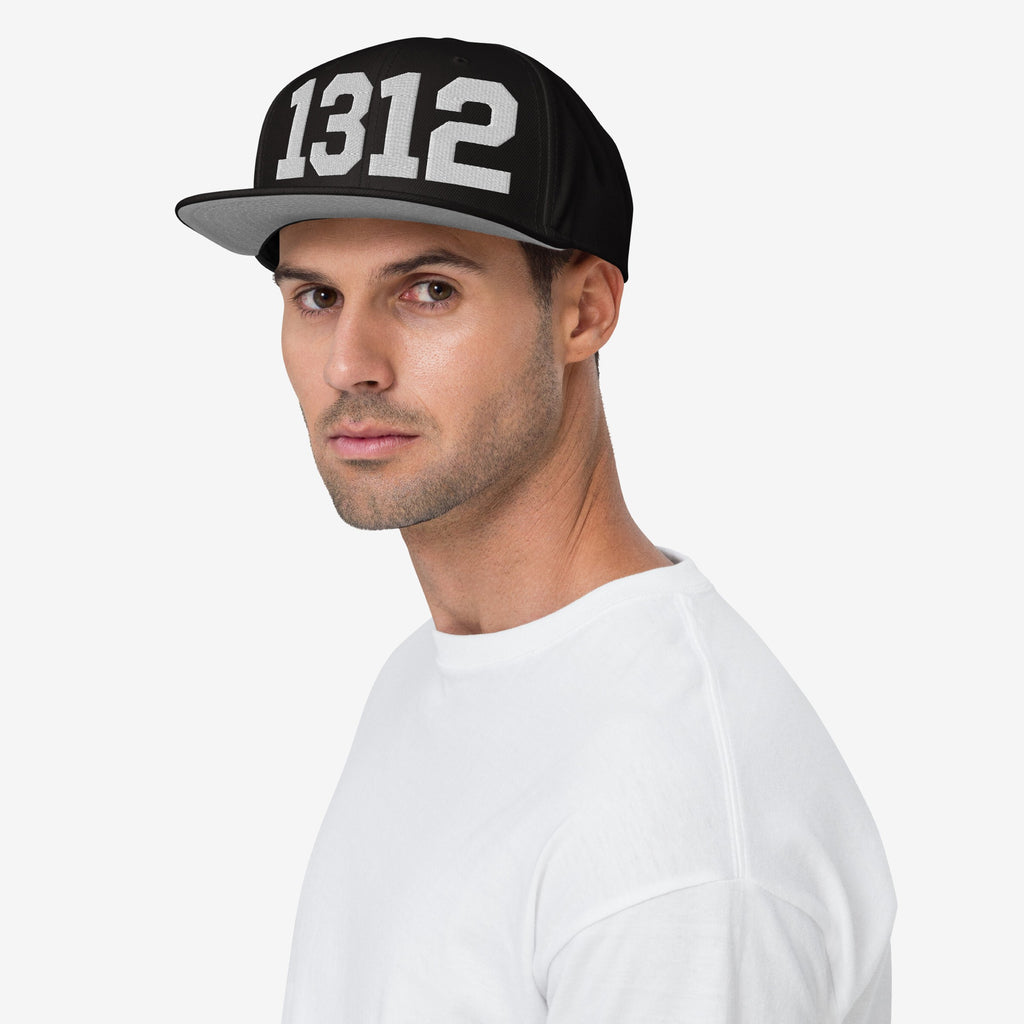 Young man wearing a 1312 ACAB Hat, featuring bold white numbers on a black flat-brim design, symbolizing protest and accountability, posed against a neutral background.