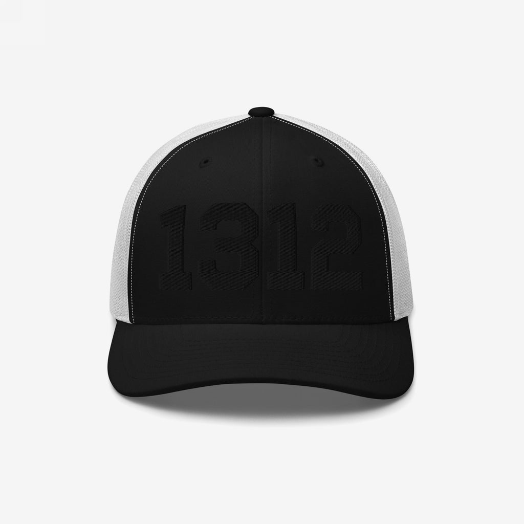 Black-and-white trucker cap with 1312 embroidered in black on the front, symbolizing ACAB. The cap features black front panels and brim, with white mesh sides and back.