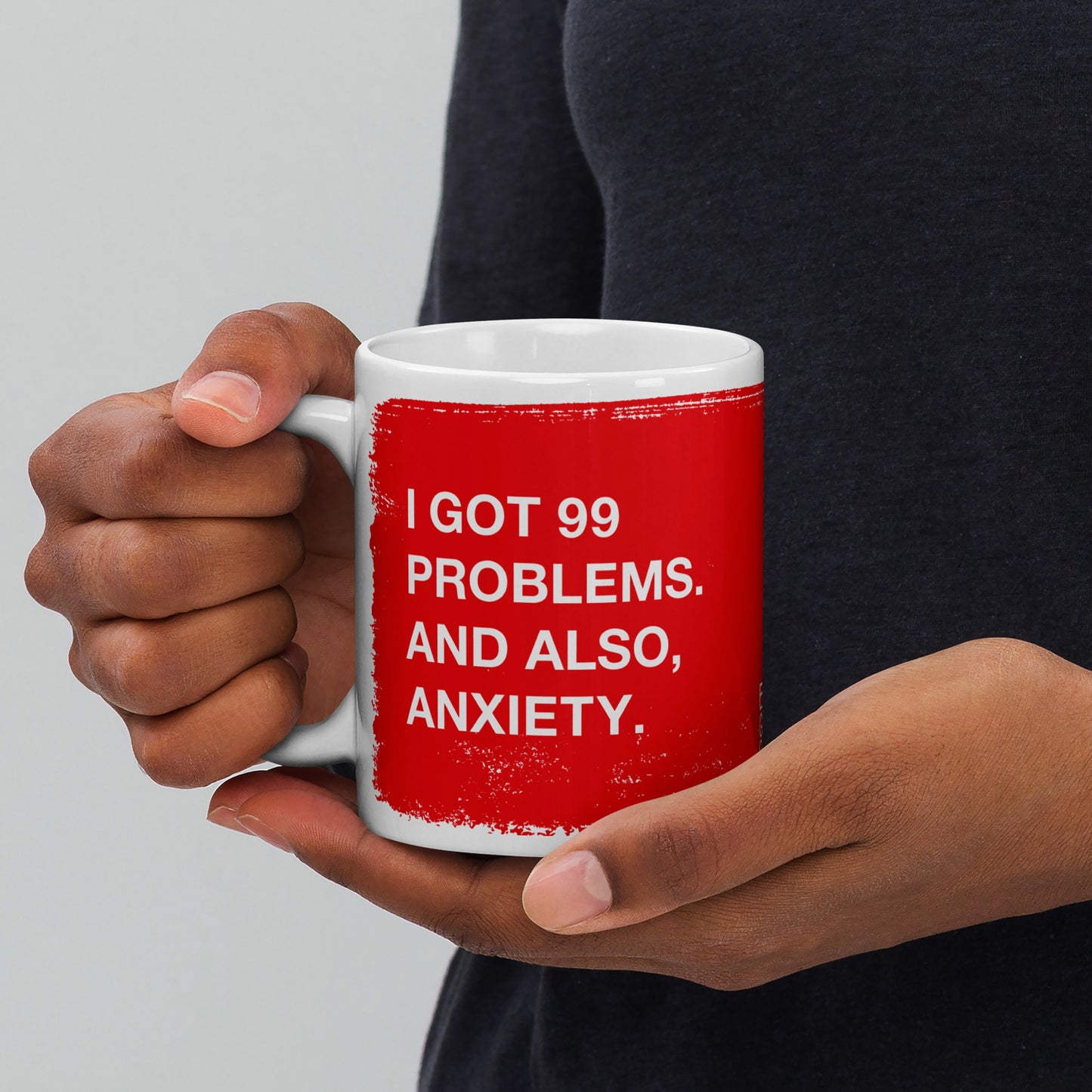 Close-up of a person holding the 99 Problems Mug, featuring a bold red panel with I GOT 99 PROBLEMS. AND ALSO, ANXIETY. in white text, capturing a blend of humor and solidarity.