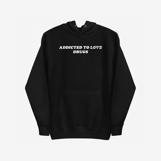 Black hoodie with Addicted To Love/Drugs in bold white and red text, featuring kangaroo pocket and drawstring hood. A thought-provoking piece reflecting personal struggles and self-awareness.