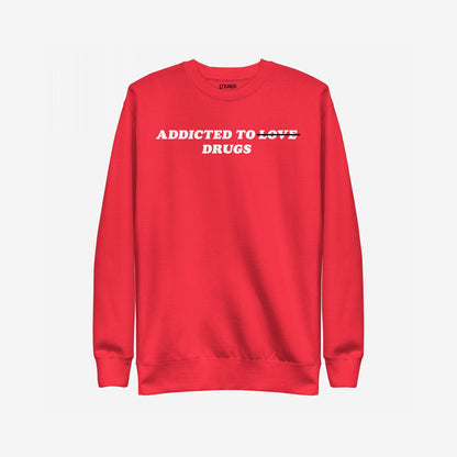 Addicted To Love / Drugs Hoodie & Sweatshirt features bold white text with 'LOVE' crossed out, replaced by 'DRUGS', capturing themes of personal struggle and self-awareness on a bright red crewneck.