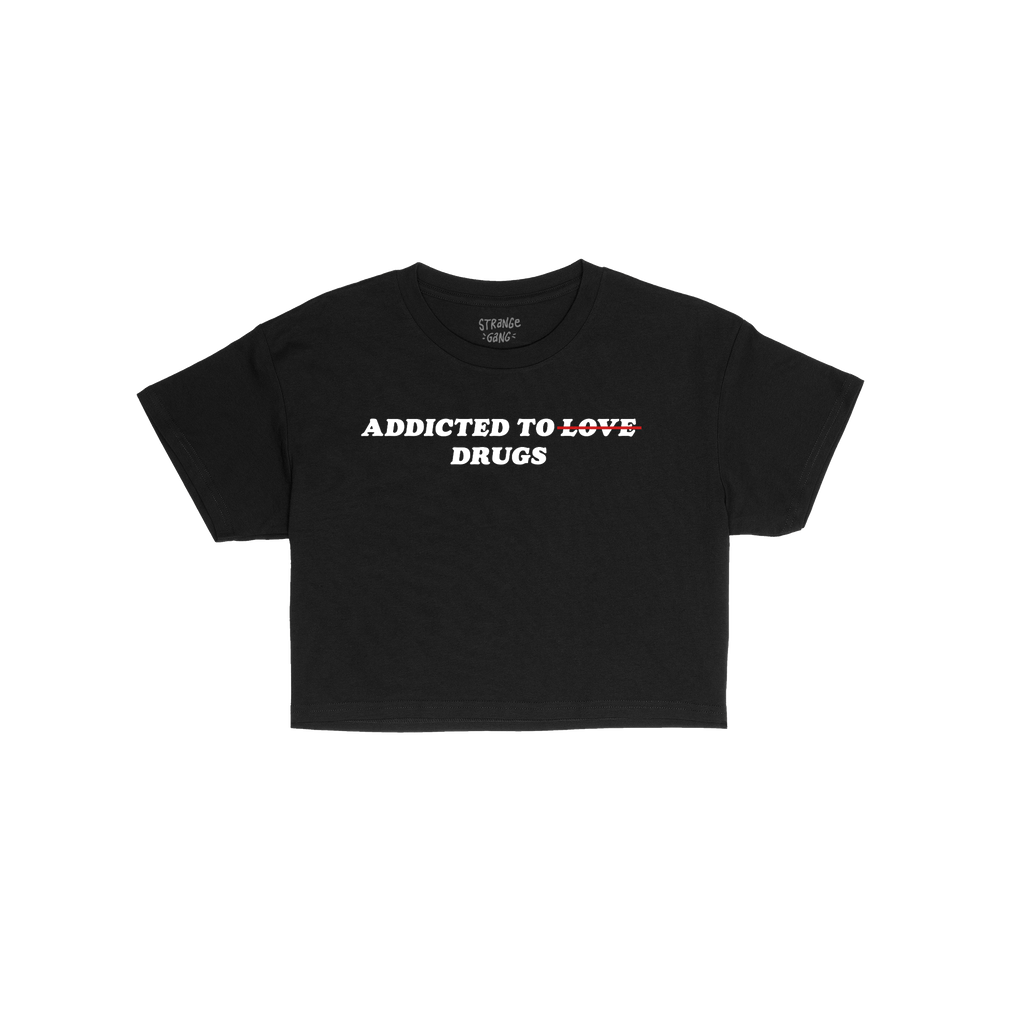 Addicted To Love / Drugs Women's Baby Tee: A cropped black tee with a bold slogan, humorously striking out LOVE for DRUGS in