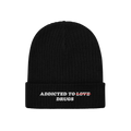Black knit beanie featuring embroidered bold text "Addicted To Love" crossed out and replaced with "Drugs" from the Addicted 