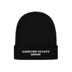 Black knit beanie featuring embroidered bold text "Addicted To Love" crossed out and replaced with "Drugs" from the Addicted 