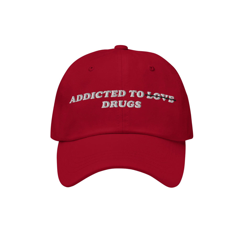 Red embroidered Addicted To Love / Drugs Hat with "Love" crossed out and replaced by "Drugs" in bold retro design.