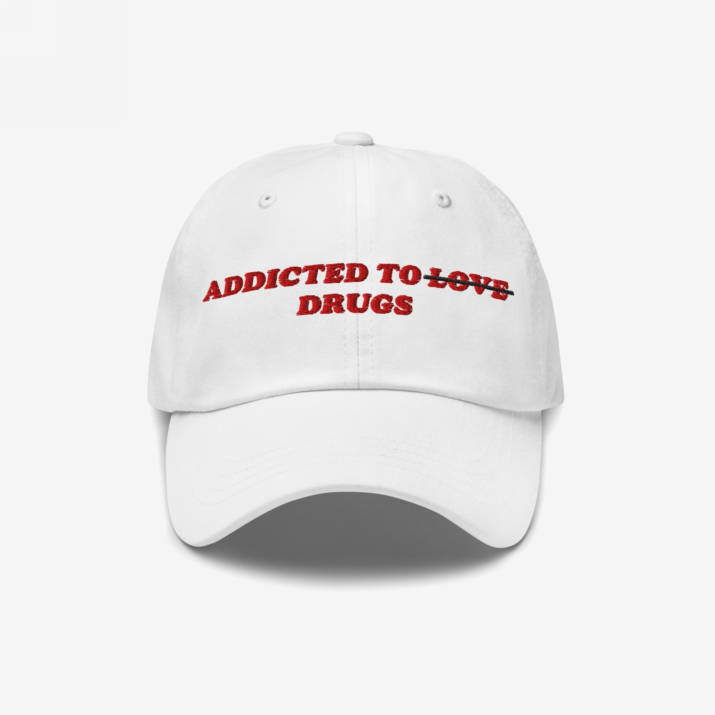 White snapback hat with "Addicted To Love" crossed out and replaced by "Drugs" embroidered in red, titled Addicted To Love / Drugs Hat.