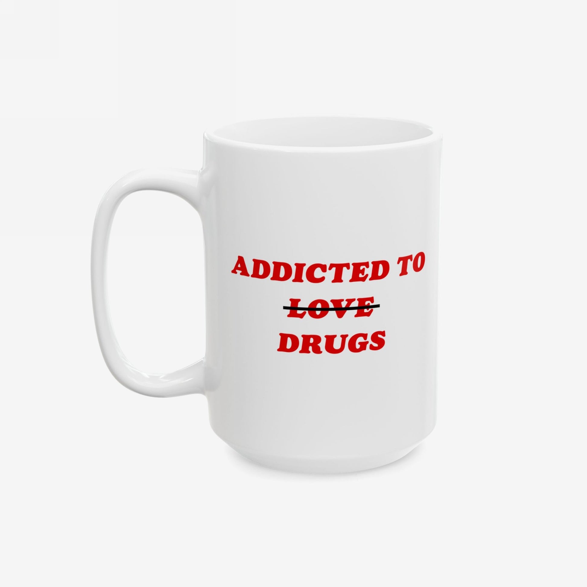 White ceramic mug titled Addicted To Love / Drugs Mug with bold red text, humorously swapping love for drugs through a strikethrough, reflecting mental health awareness and sharp humor.