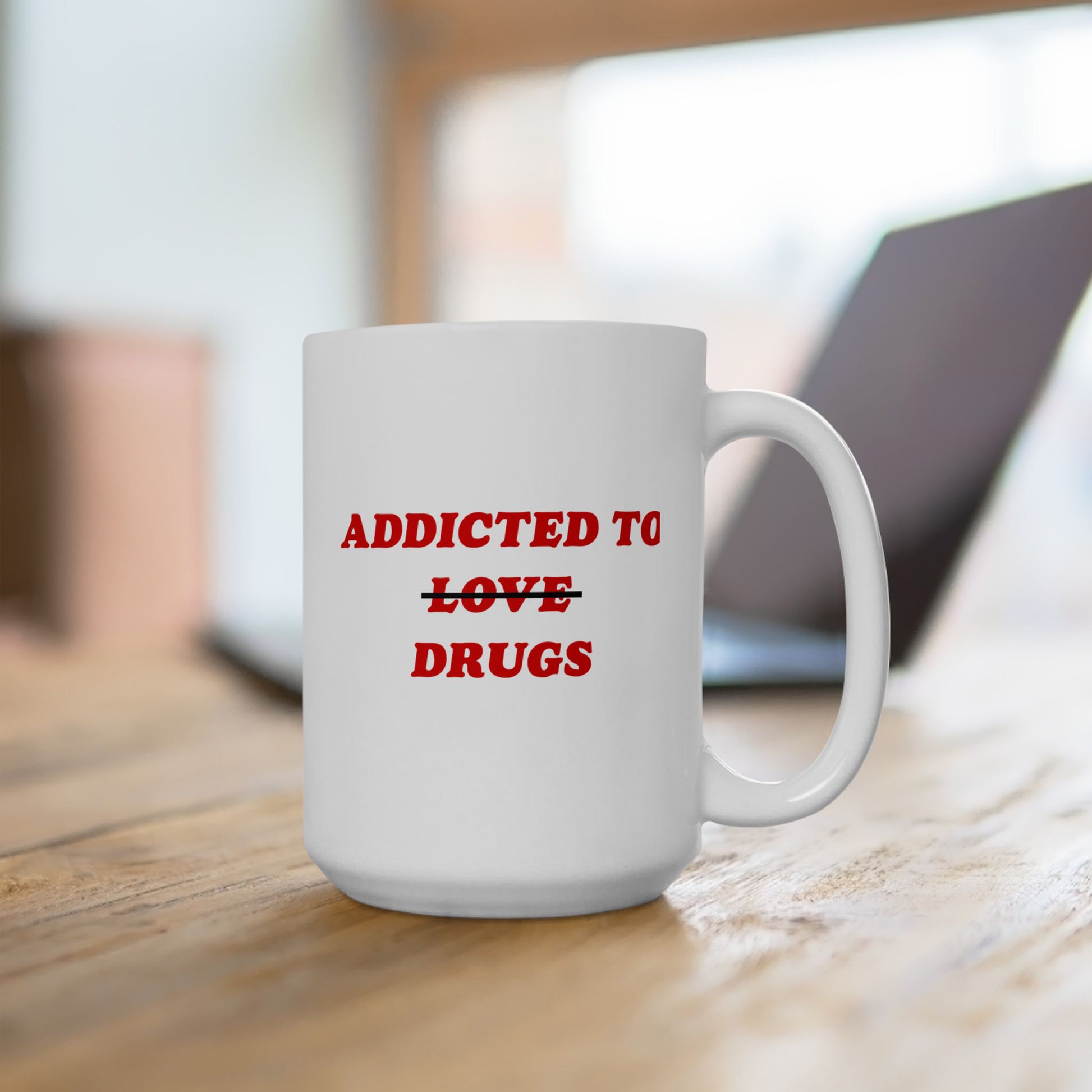 White ceramic mug on wooden tabletop, featuring bold red text: ADDICTED TO ~LOVE~ DRUGS. Perfect for expressing mental health humor and resilience. Ships from the EU, supports Amnesty International.