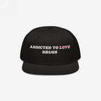 Black snapback hat with embroidered text "Addicted To Love" crossed out and replaced by "Drugs" on the Addicted To Love / Drugs Hat.