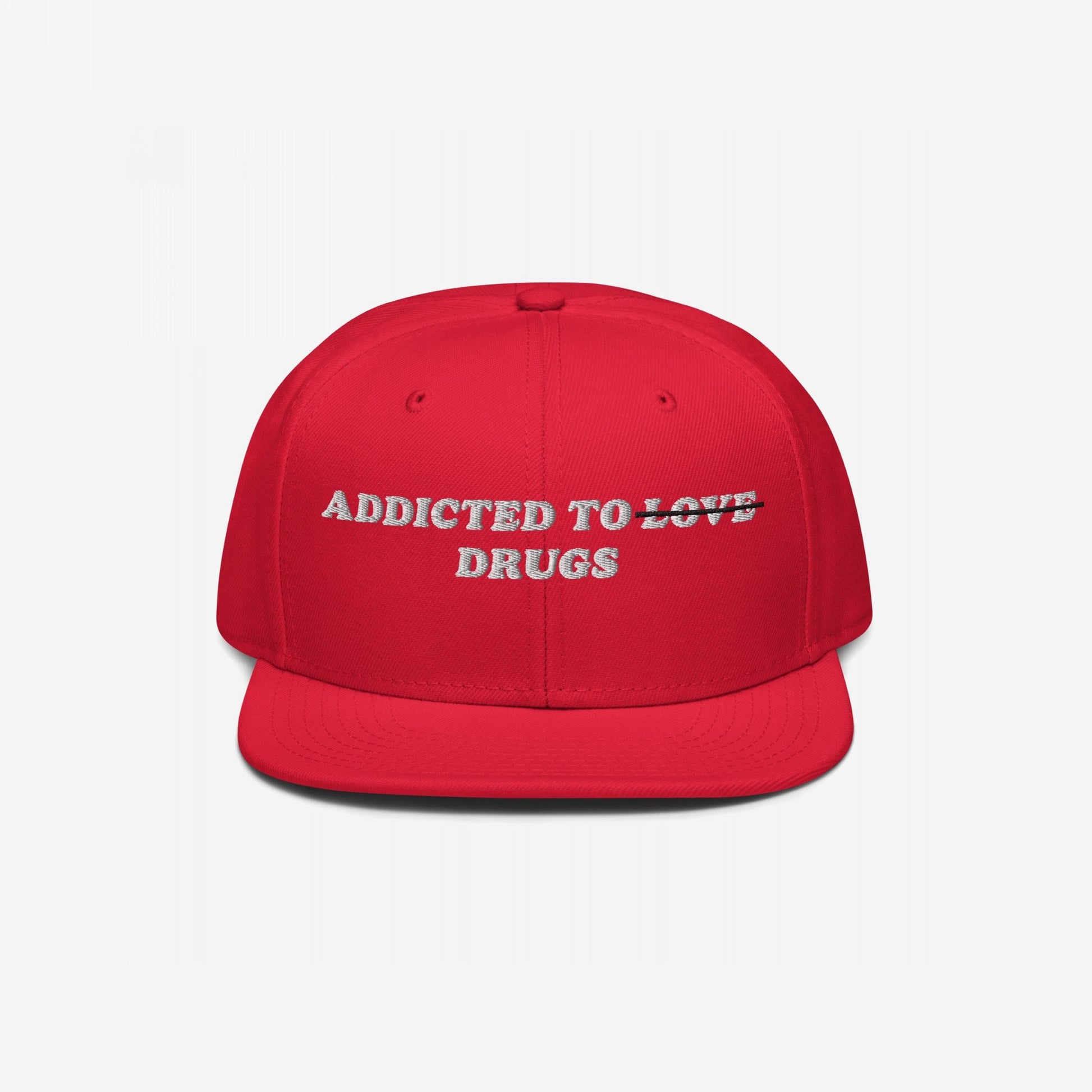 Bright red, flat-brim snapback cap with Addicted To Love/Drugs Hat embroidered. LOVE is struck through, displaying DRUGS beneath, symbolizing raw honesty over romantic illusions.