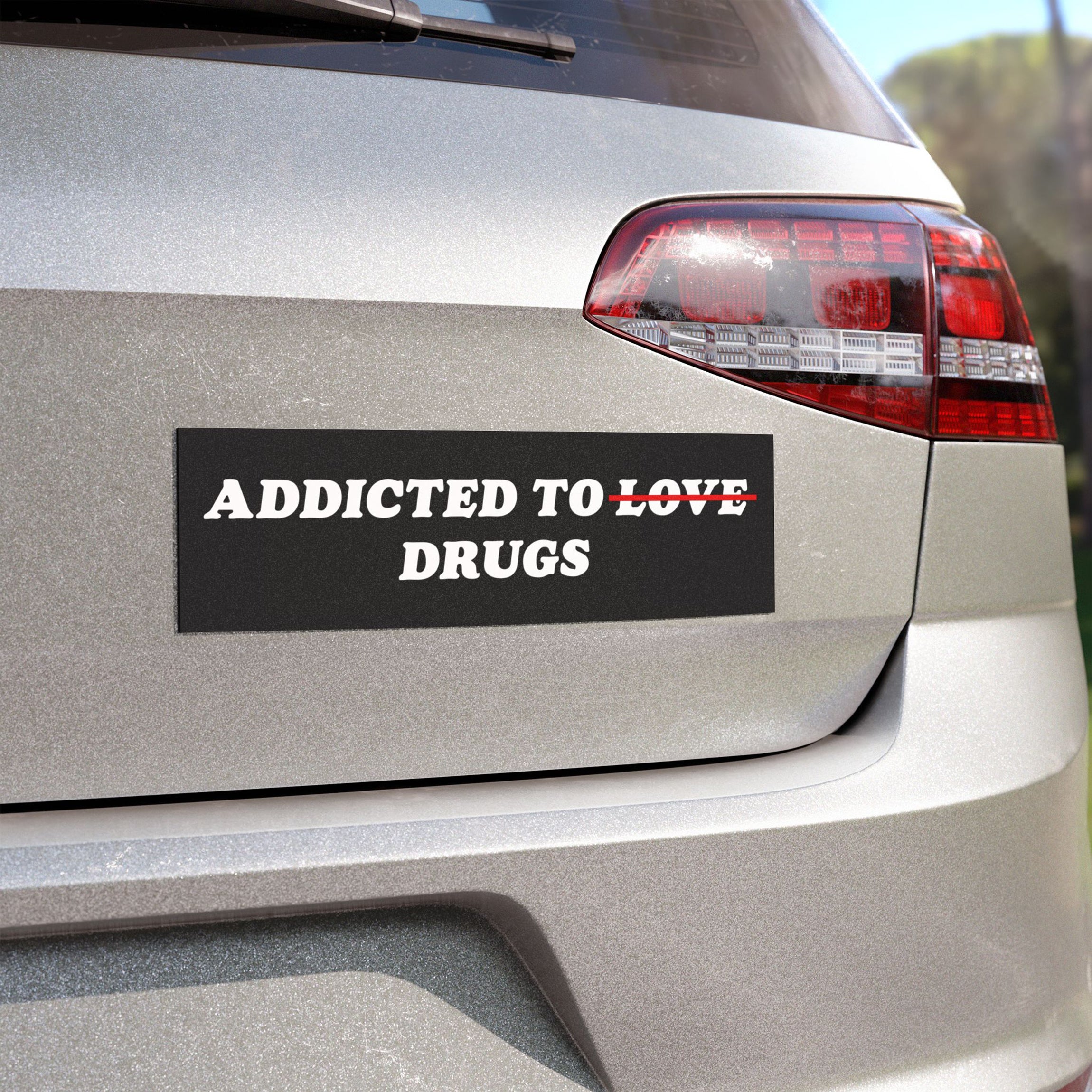Addicted To Love / Drugs Sticker & Magnet on car bumper with bold white text on black background, vinyl sticker version shown outdoors.