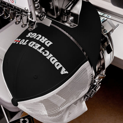 Addicted To Love / Drugs Hat being embroidered on an industrial machine, showcasing 'Addicted to Drugs' with 'TO' crossed out, highlighting the cap's bold message and edgy design.