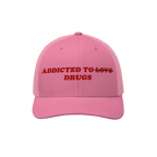 Pink snapback hat with embroidered text "Addicted To Love" crossed out and replaced by "Drugs" from the Addicted To Love / Dr