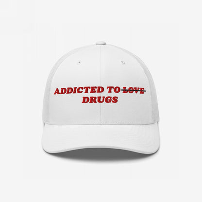 White trucker-style cap with red embroidery, reading ADDICTED TO with LOVE struck through and DRUGS below. The Adulting Sucks Hat conveys a candid, rebellious message for the overwhelmed.