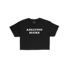 Adulting Sucks Women's Baby Tee features bold white text on a black cropped shirt, expressing relatable humor for life's chal
