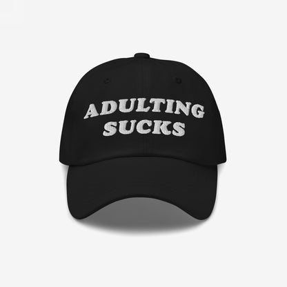 Black cap with “ADULTING SUCKS” embroidered in white, capturing a relatable sentiment for millennials and professionals. Perfect for expressing frustration with adult responsibilities.