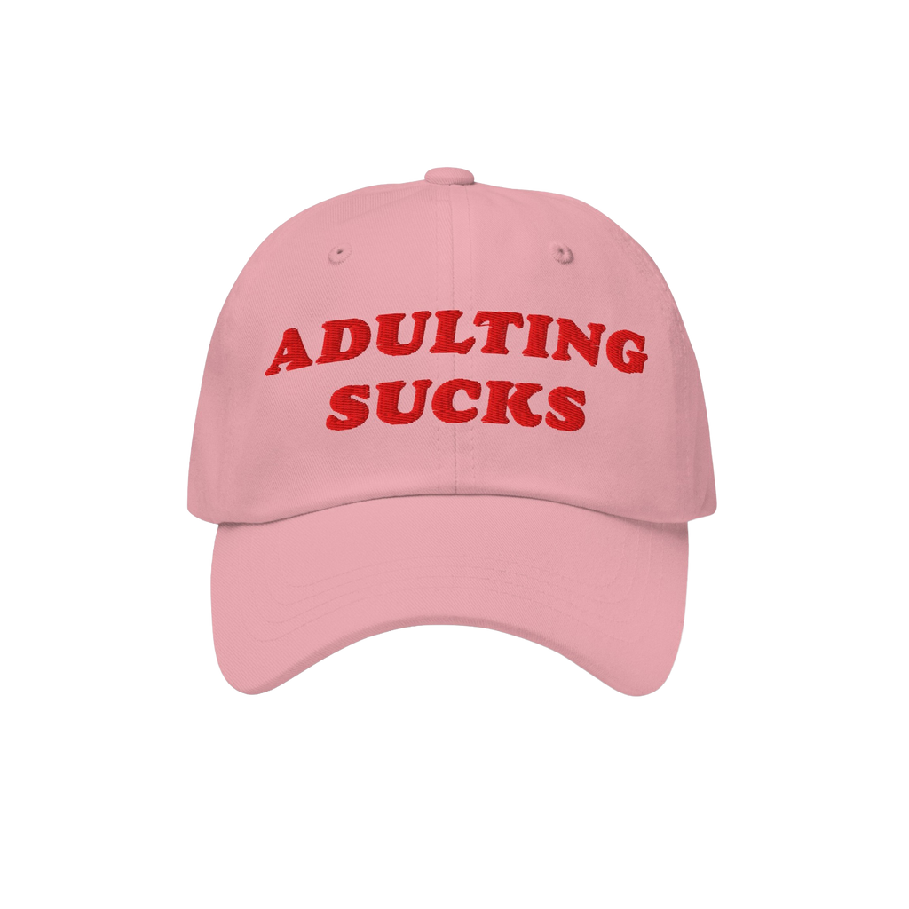 Pink baseball-style cap with bold red embroidery reading ADULTING SUCKS, highlighting a playful, relatable message for those 