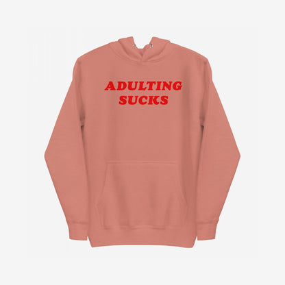 Adulting Sucks Hoodie & Sweatshirt features a muted coral pullover with bold red “ADULTING SUCKS.” text, capturing retro style and humor, ideal for expressing adult life challenges.